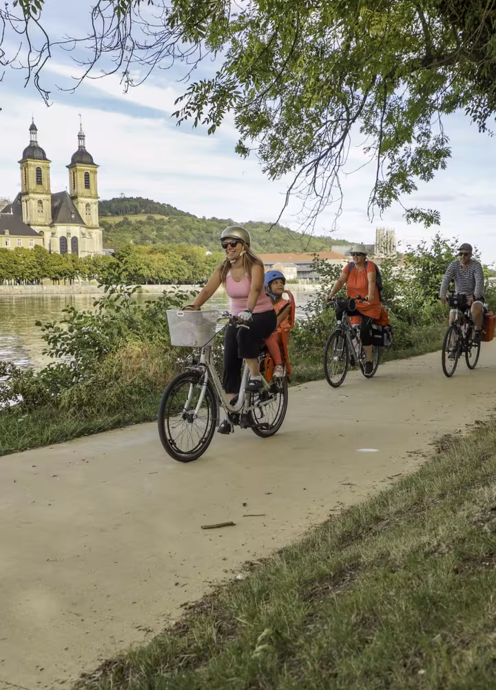 Famille à vélo sur le halage de la Moselle à Pont-à-Mousson devant l'abbaye des Prémontrés